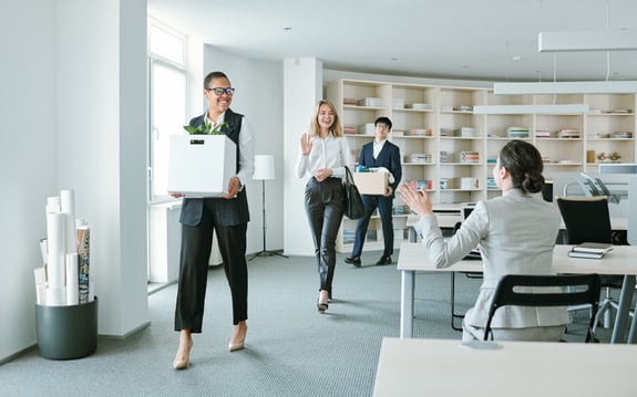 employees carrying boxes in office