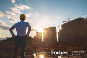 construction worksite manager looks at projects during sunset