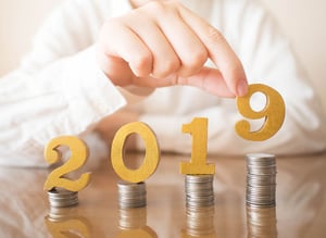 2019 depicted on top of stacks of coins